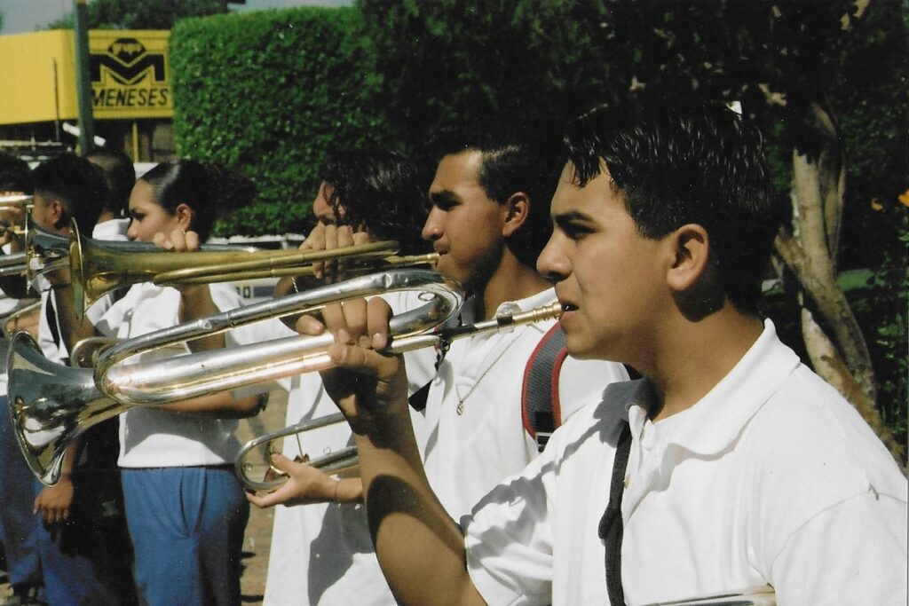 A row of trumpet players blow their instruments during Revolution Day in Morelia