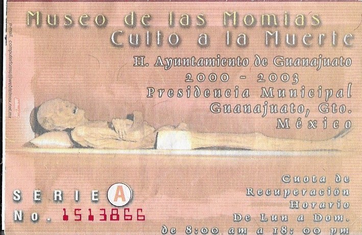 Ticket stub depicting a morbid scene from the Museo de las Momias in Guanajuato. Skeleton lies horizontal with skull on pillow.