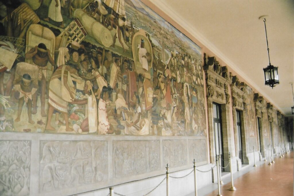 mural strewn wall at the national place in Mexico city depict Aztec scenes.