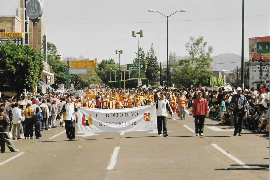 Huge crowd scene as citizens on either side of the main street welcome the start of the national revolution day in Morelos. 