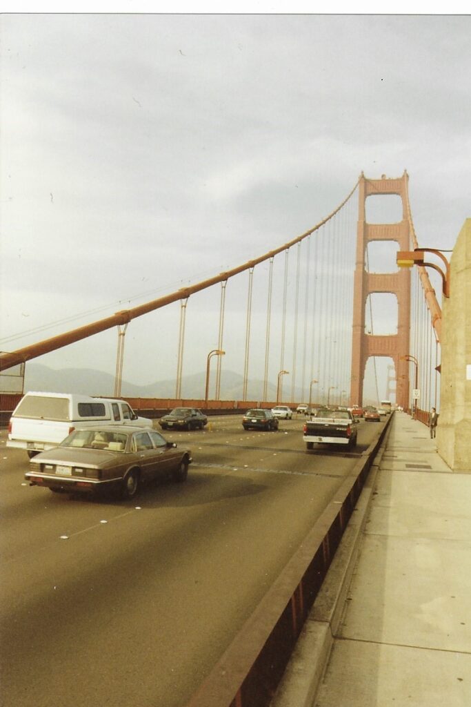 Multiple lanes of traffic flow across the Golden Gate Bridge.