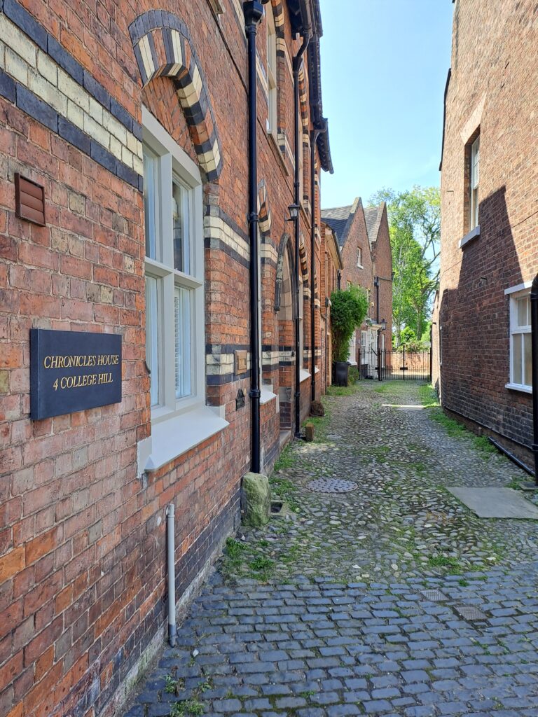Short cobbled street in Shrewsbury, England, with Robert Clive's former 18th century house at one end, behind an iron gate.