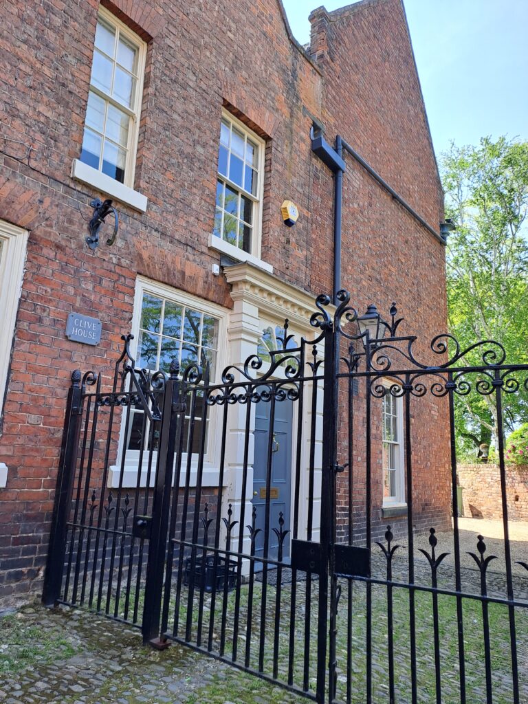 Short cobbled street in Shrewsbury, England, with Robert Clive's former 18th century house at one end, behind an iron gate.